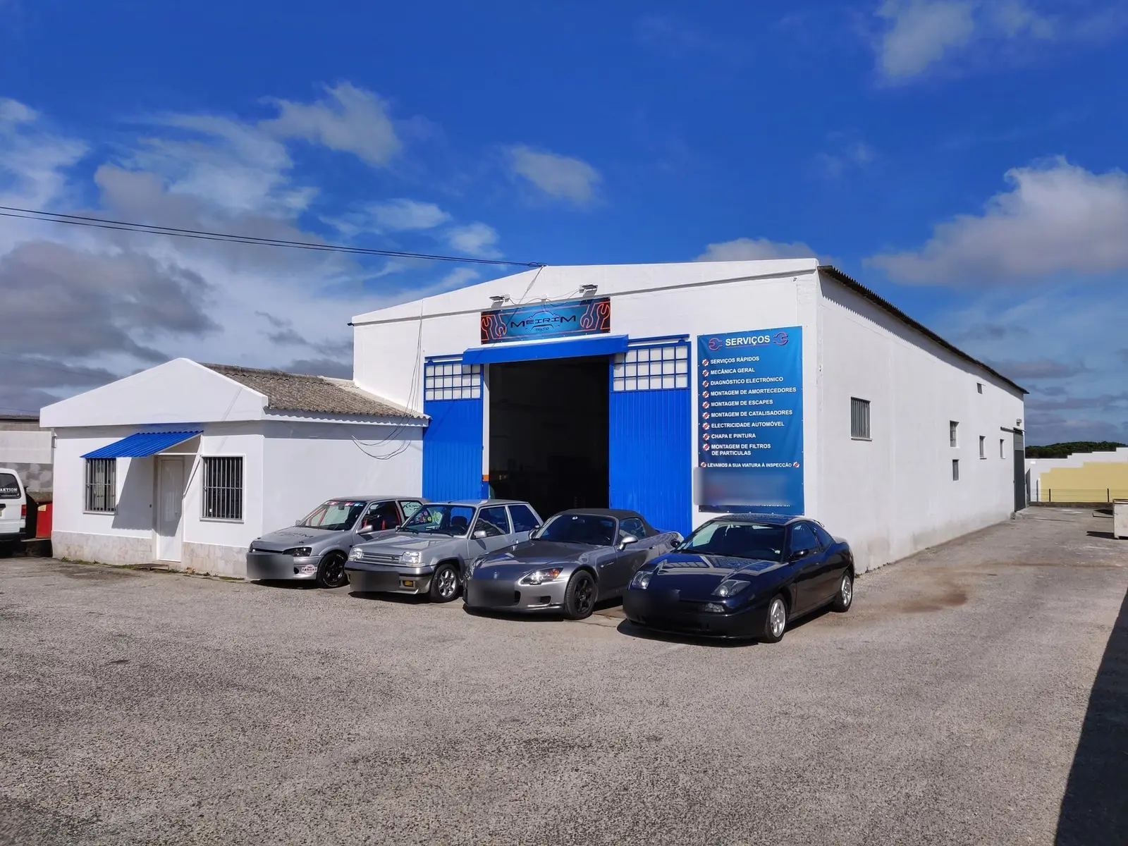 Fachada da oficina AutoMeirim com carros à porta